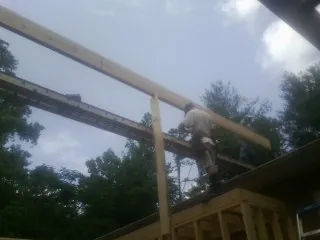 Carpenter setting a ridge beam over a new addition frame — Ice Dam Removal by Roofing Brothers in Port Matilda