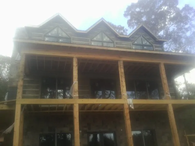 Dormers and porch framing on a large log home under construction — Roof Coating work by our crew in Port Matilda