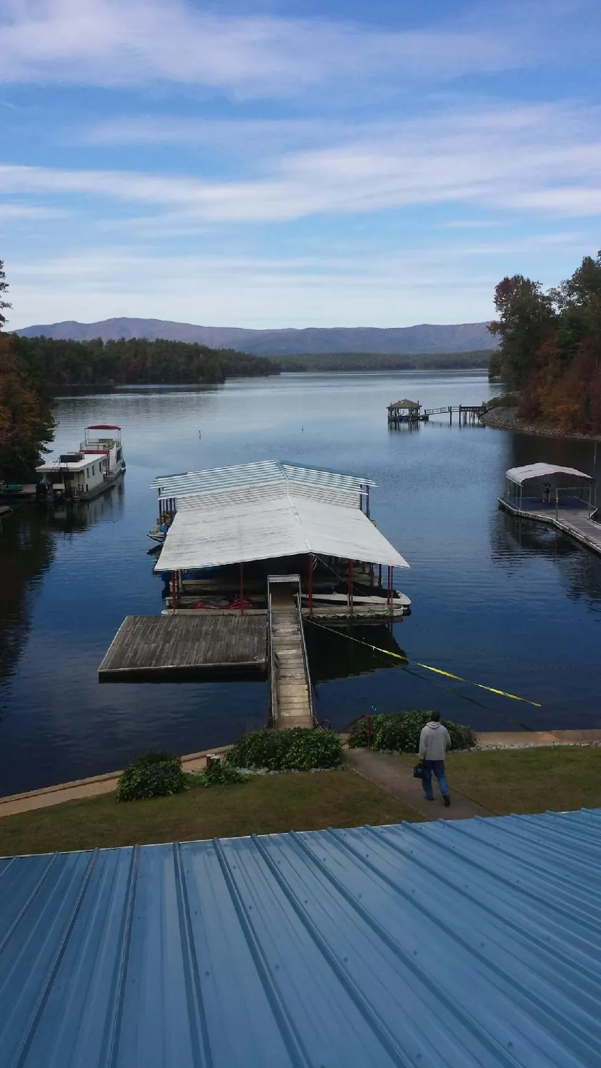View across a lake from a newly installed blue metal roof in Port Matilda